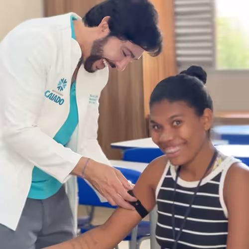 Dr. Ricardo Caiado mede a pressão de uma jovem durante o atendimento na comunidade