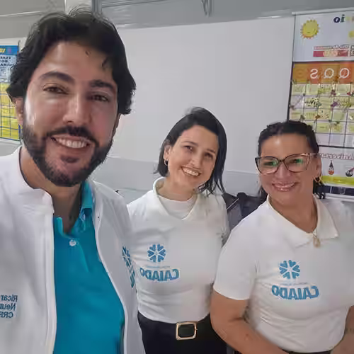 Dr. Ricardo Caiado ao lado de duas voluntárias com a camiseta do projeto